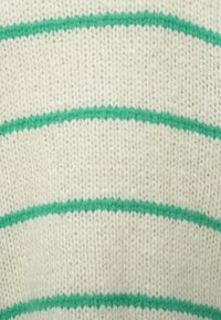 Κοντινή λήψη κρεμ μάλλινου υφάσματος με ομοιόμορφα κατανεμημένες οριζόντιες πράσινες ρίγες.