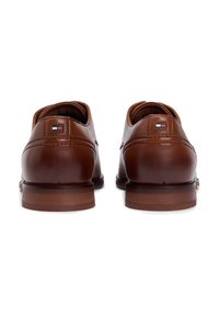 Καφέ δερμάτινα παπούτσια με λείο υφή, στρογγυλή μύτη και ραμμένες λεπτομέ ρειες. Διαθέτουν μικρή ετικέτα με λογότυπο στη φτέρνα και στιβαρή καφέ σόλα.