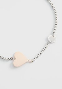 Zilveren ketting met een minimalistische rosegouden hartbedel met een gepolijste afwerking en een ronde sluiting.