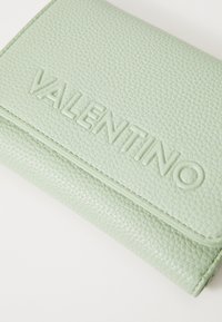 Mätová koženková peňaženka s textúrou a embosovaným logom "VALENTINO", s preklápacím dizajnom a viditeľnými švami.