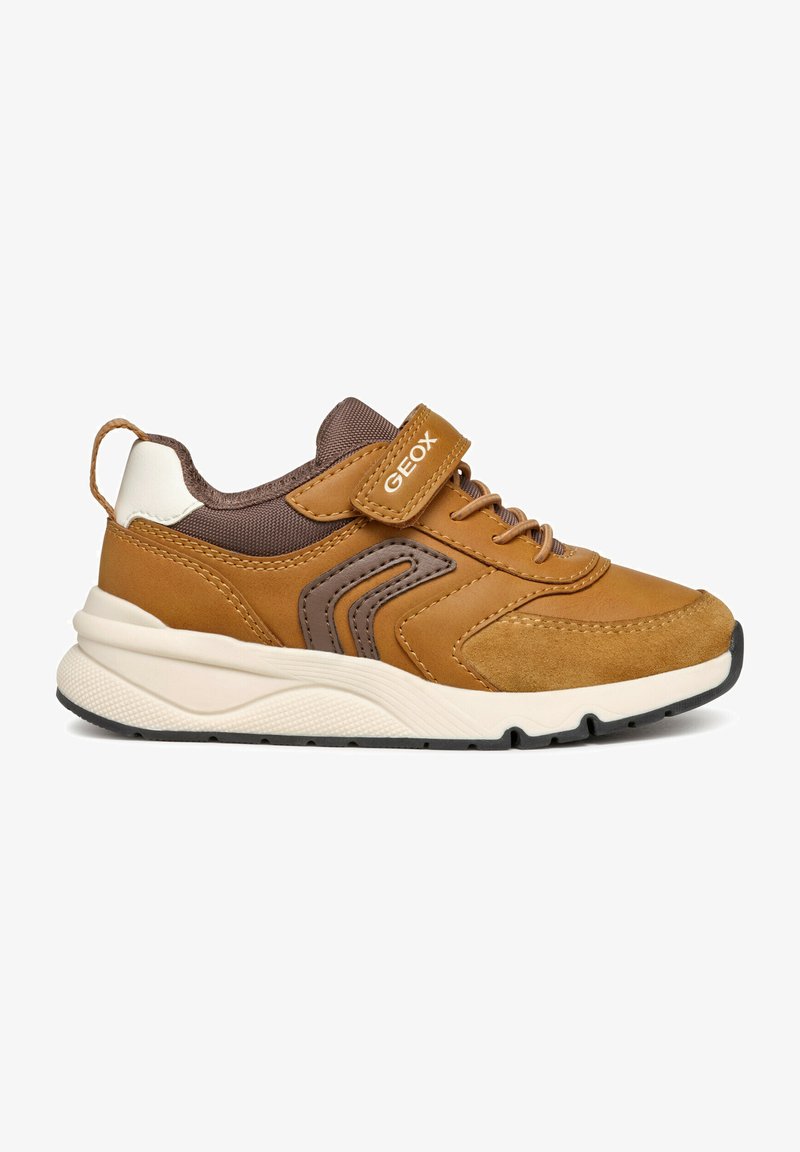 Zapatillas de cuero marrón con detalles de ante, una correa de velcro y una media suela texturizada blanca. Cuenta con una suela exterior de goma negra para mayor agarre.