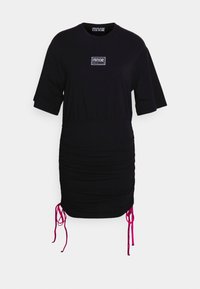 Zwarte jurk met korte mouwen, gerimpelde zijkanten en roze trekkoorden. Heeft een klein logoplaatje op de borst. Gemaakt van zachte stof.