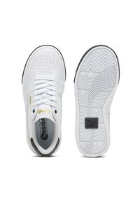 Vit Puma-sneaker med perforerad tå, vita snören, guldfärgad logga på sidan och tungan, samt texturerad sula med svart Puma-logga.