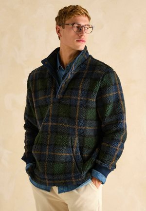 Fleece-Pullover im karierten Muster mit blauen, grünen und braunen Farben. Mit einem halben Reißverschluss und einer vorderen Taschenklappe. Weiche Textur.