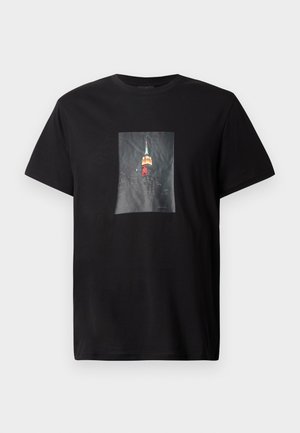 T-shirt in cotone nera con un'immagine stampata del Empire State Building di notte, che mette in risalto luci colorate e un paesaggio urbano dettagliato.