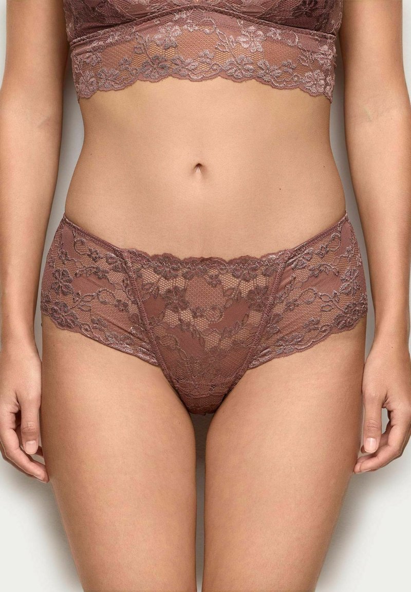 Kanten bralette en bijpassende hoog uitgesneden slip in een zachte mauve kleur, met bloemmotieven en gekartelde randen. Fijne textuur over het geheel.