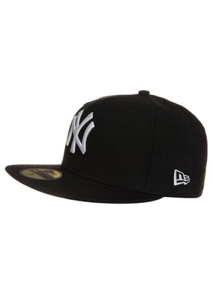 Black New Era cap with a flat brim, featuring a prominent white embroidered New York Yankees logo on the front and a white logo on the side.