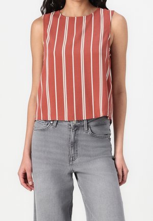 Rode mouwloze top met verticale crèmekleurige strepen, ronde halslijn en een ontspannen pasvorm. Gecombineerd met lichtgrijze jeans met een klassiek ontwerp.
