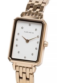 Reloj rectangular en oro rosa con esfera blanca, engastado con cristales como marcadores de horas y una correa de pulsera con eslabones. Cuenta con una corona en el lateral.