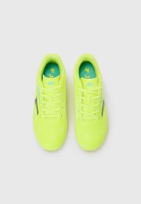 Scarpe da atletica gialle brillanti con una superficie liscia, dotate di una soletta turchese e accenti neri sui lati, progettate per le prestazioni.