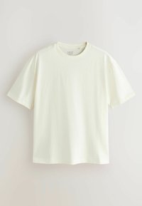 Lihtne valge lühikeste varrukatega t-särk, ümara kaelusega, riputatud hele tausta vastu, kaelas sees nähtava brändisildiga.