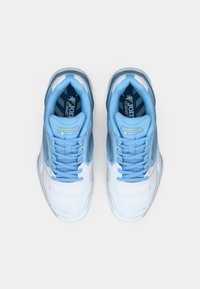 Para niebiesko-białych sneakersów Joma widoczna z góry na jasnym tle, z zawiązanymi sznurowadłami i widocznym logo marki wewnątrz.