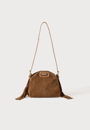 Sac à épaule en daim marron avec une longue bandoulière, une découpe rectangulaire de la poignée et des détails à pompons sur les côtés sur fond blanc.