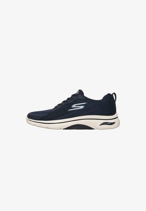 Zapatilla Skechers Arch Fit negra con suela blanca, diseño con cordones y logo en el lateral y talón para soporte del arco.