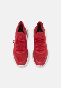 Scarpe sportive rosse con tomaia in rete traspirante, lacci piatti e suola in gomma. Punta arrotondata e collare imbottito per il comfort.