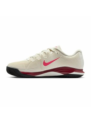 Beige athletic shoe with ribbed texture, red swoosh logo, and maroon accents on the sole. Features a flexible black rubber outsole.
