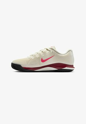 Chaussure de sport beige avec texture côtelée, logo Swoosh rouge et accents bordeaux sur la semelle. Dotée d'une semelle extérieure en caoutchouc noir flexible.