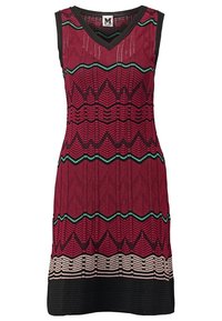 Robe sans manches à décolleté en V avec une base rouge, des motifs en zigzag et rayures noirs, des accents horizontaux verts, et un ourlet noir.