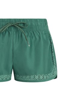 Zelené športové šortky s elastickým pásom, sťahovacou šnúrkou a detailom laserom rezaného vzoru pozdĺž okrajov.