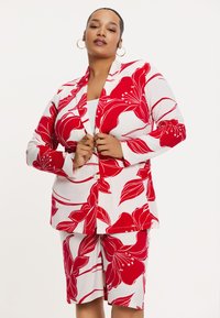 Rode en witte bloemenprint blazer met bijpassende shorts. Kenmerkt zich door grote rode bloempatronen en een soepele textuur. Knopensluiting op de blazer.