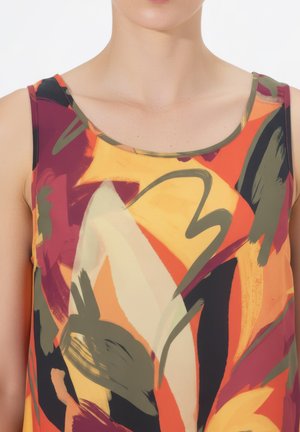 Frau trägt ärmelloses Oberteil mit abstraktem Pinselstrichmuster in Orange, Gelb, Schwarz, Burgund und Olivgrün.