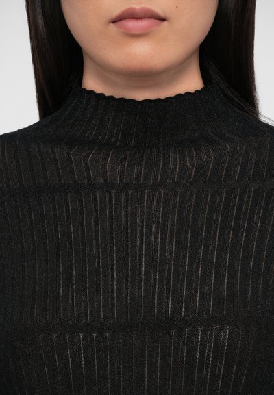 Top negru din tricot cu un guler înalt cu margini ondulate. Prezintă dungi verticale și un material moale, texturat. Vedere detaliată.