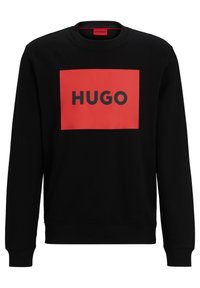Sudadera negra con cuello redondo, que presenta un logo rectangular rojo intenso con la palabra "HUGO" en texto negro centrado en el frente. Tela suave.