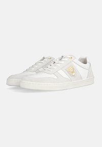 White suede and leather sneakers featuring a textured design, flat white soles, and a small gold accent on the side logo.