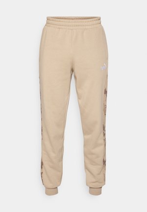Beige Puma sweatpants with elastic waistband, side pockets, cuffed ankles, and abstract brown camo stripes along the outer legs.