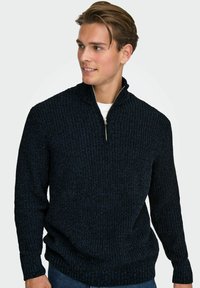 Marineblauer Strickpullover mit einem halben Reißverschluss-Kragen, strukturiertem Muster, gerippten Bündchen und Saum, aus einem weichen, warmen Material gefertigt.