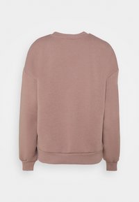 Różowa bluza z luźnym krojem, z okrągłym dekoltem, ściągaczami przy mankietach i u dołu, wykonana z miękkiego materiału bawełnianego.