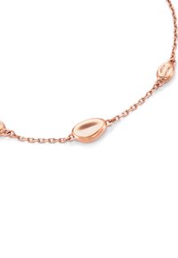 Halsband i roseguld med en delikat kedja som har släta, små stenar som detaljer, med en glänsande, reflekterande yta.