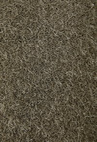 Tissu texturé dans des tons de vert-brun terreux, avec des fibres fines et une apparence douce et hirsute, suggérant une sensation moelleuse et confortable.