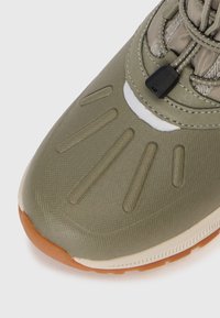 Zöld, textúrált sneaker gumi talppal, lekerekített orral, díszítő vonalakkal és a tetején állítható fűzőzárral.