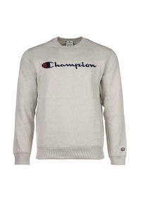 Sudadera gris claro fabricada en una mezcla de algodón, con un logo en marino "Champion" en el pecho y un pequeño parche con el logo en la manga izquierda.