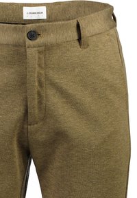 Pantaloni in cotone marroni e texurizzati con chiusura a bottone, passanti per cintura e una piega frontale per un aspetto sartoriale.