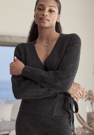 Dunkelgrauer Strickpullover mit langen Ärmeln, einem tiefen V-Ausschnitt und Taillenkordeln. Weiche Textur mit lockerer Passform. Minimalistisches Design.