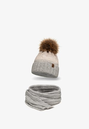 Gebreide wintermuts met een bruine nepbont pompoen, crème kleur, en een bijpassende grijze geribbelde sjaal met een textuurafwerking.