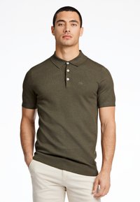 Olivgrön kortärmad polo-shirt av texturerad stickad tyg med krage, tre knappar fram och en liten logotyp på bröstet.