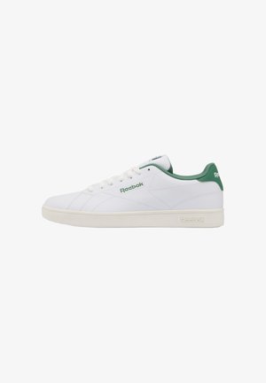 White low-top Reebok sneaker with green inner lining, green heel tab, and logo on side and sole, shown in side profile on white background.