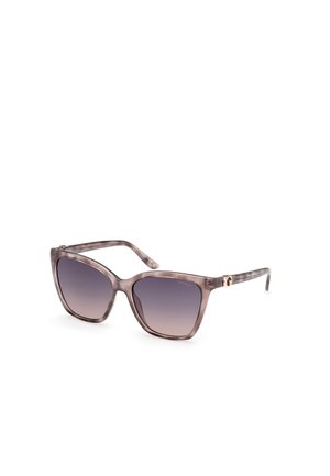 Gafas de sol de gran tamaño con un marco transparente gris y lentes morados en degradé. Presentan sutiles acentos metálicos en las patillas.