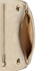 Sac à main en suède beige avec fermeture éclair et quincaillerie dorée, doté d'un intérieur spacieux et d'une doublure lisse et texturée.