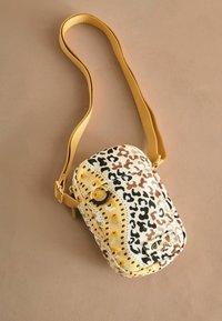 Borsa a tracolla gialla e stampata con motivo animale, superficie testurizzata, tracolla regolabile e un accento in metallo a cerchio sul davanti.