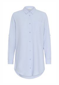 Chemise bleu clair à manches longues avec col boutonné, poche poitrine unique, ourlet arrondi et manches retroussables avec pattes. Tissu doux au toucher.
