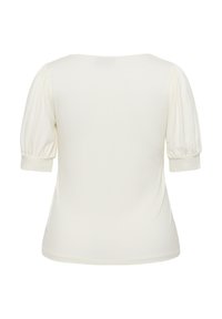 Haut crème avec des manches courtes et bouffantes, texture douce et encolure ronde. Design simple, ajusté, sans motifs ni accents visibles.