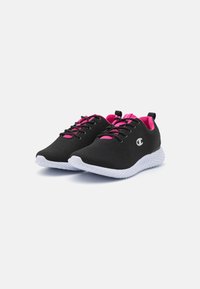 Zapatos deportivos negros con parte superior de malla, acentos rosas, cordones redondos y una suela blanca texturada. Presenta un logotipo en el lateral y una pestaña de tirón.