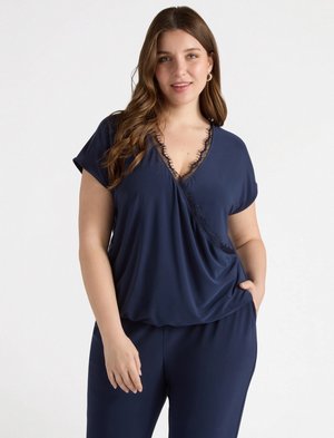 Top corto blu navy con maniche corte, scollatura a V e bordo di pizzo; texture morbida e vestibilità ampia; abbinato a pantaloni coordinati.