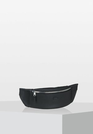 Borsetta in tessuto nero con superficie texturizzata, forma curvata e tasca frontale con zip. Presenta dettagli in metallo brunito e un logo sottile.
