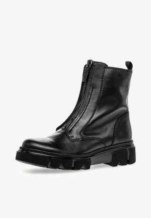 Black leather ankle boot with a side zipper, chunky rubber sole, and pronounced grip patterns. Features smooth finish and reinforced stitching details.