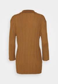 Långärmad, ribbad sweater i en varm brun färg. Har en krage och en avslappnad passform, med en mjuk, strukturerad yta.